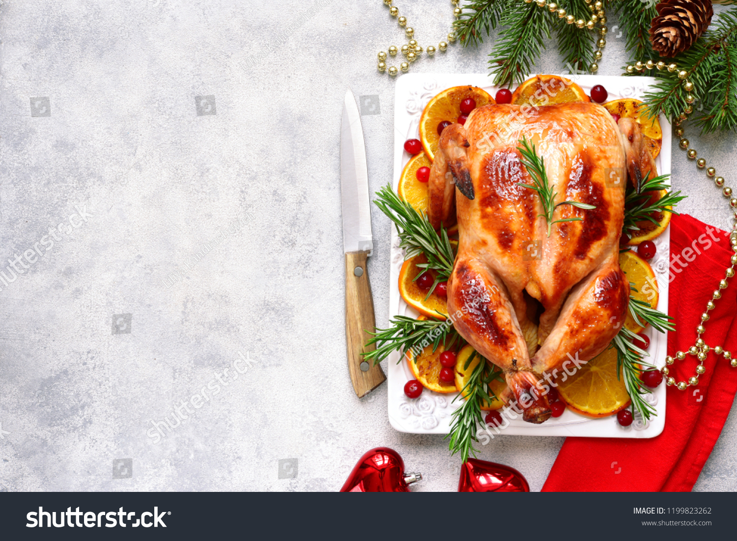 Roasted chicken with oranges , rosemary and cranberries  on a white plate over light slate, stone or concrete background.Top view with copy space. #1199823262