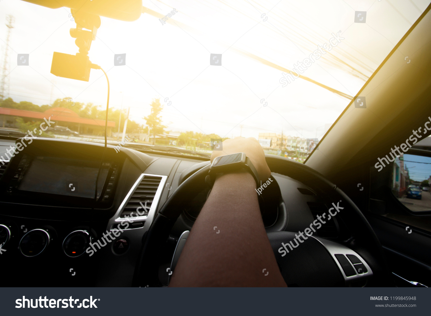 A men driving inside of car steering wheel curved in the city. #1199845948
