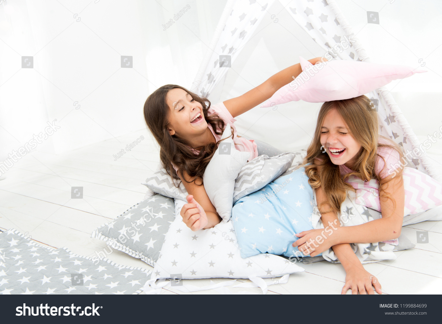 Pajamas party for kids. Girls having fun tipi house. Girlish leisure. Sisters share gossips having fun at home. Cozy place tipi house. Sisters or best friends spend time together lay in tipi house. #1199884699