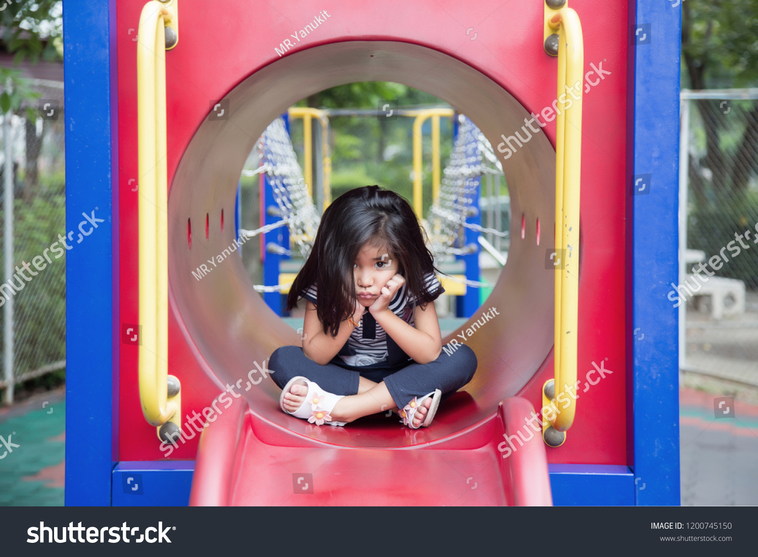 cute asian girl boring play alone in play park outdoor park in summer #1200745150