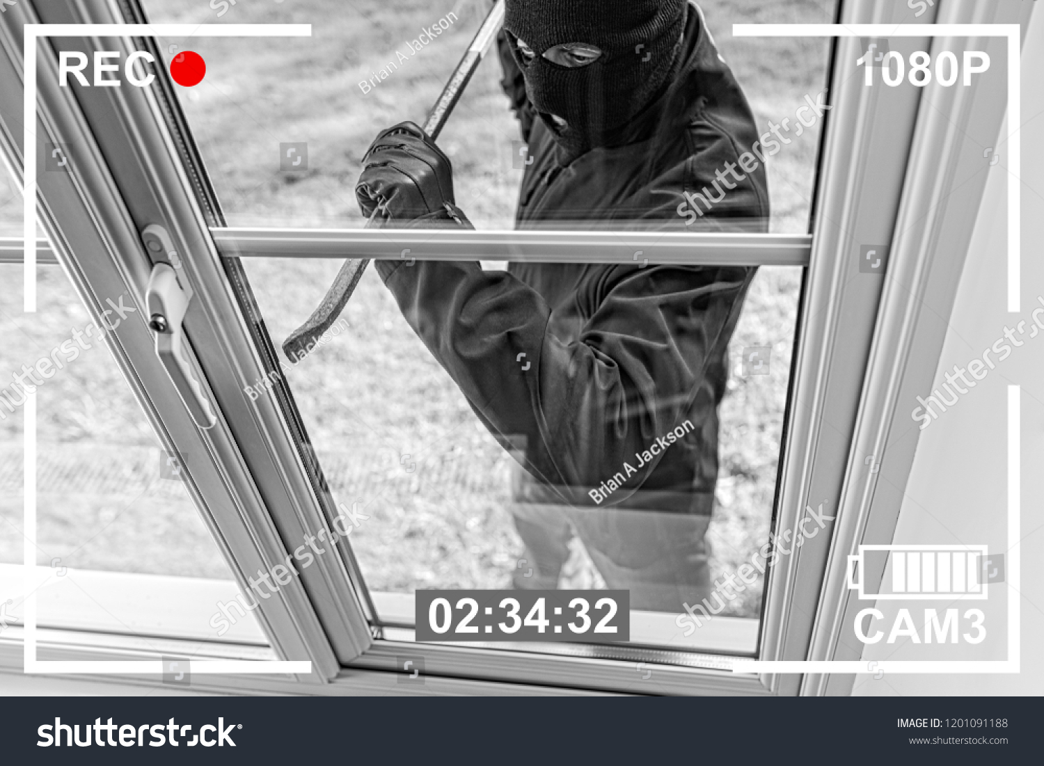 CCTV view of burglar breaking in to home through window with crowbar #1201091188