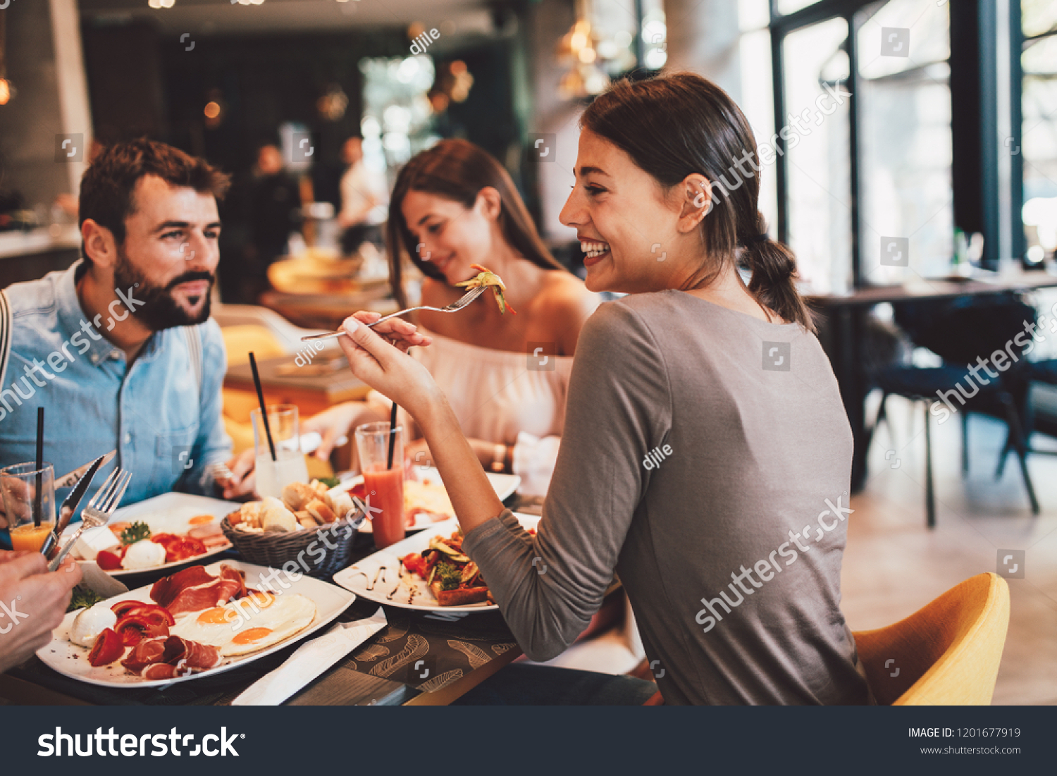 Group of Happy friends having breakfast in the restaurant #1201677919