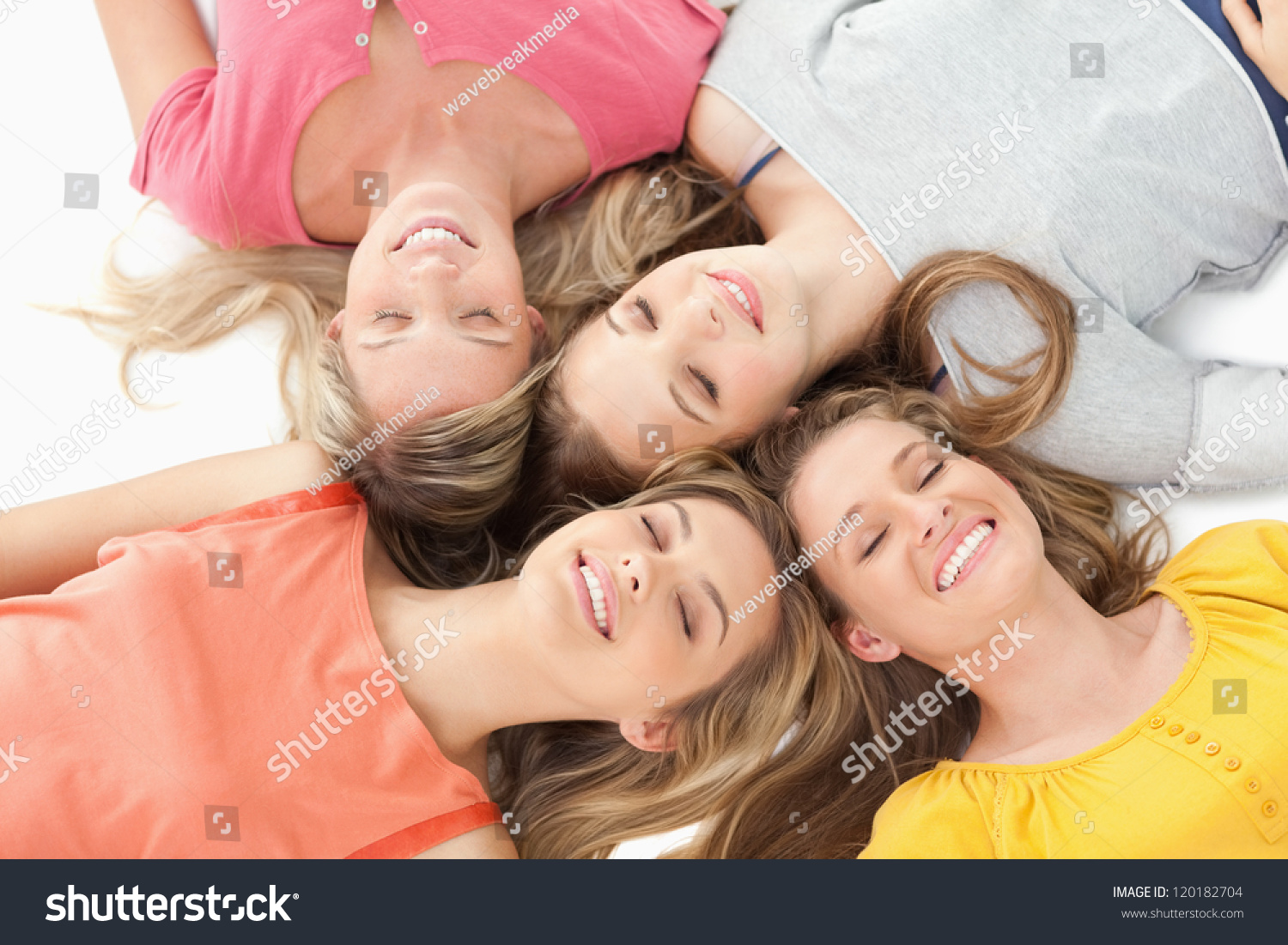 Four girls lying on the ground with their eyes closed and smiling #120182704