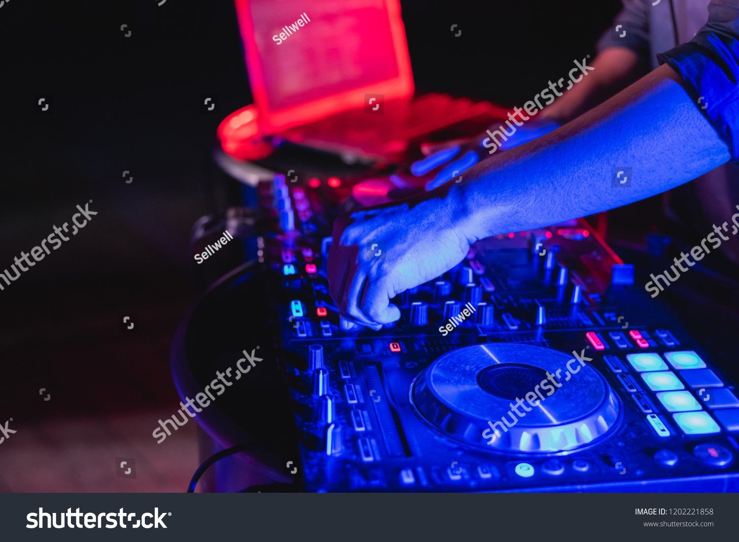 Music Concepts. DJ is rhythm music with Controller and mixer. DJ is playing the song at the party. Young are adjusting the music with the controller. The fun of music and light colors. #1202221858