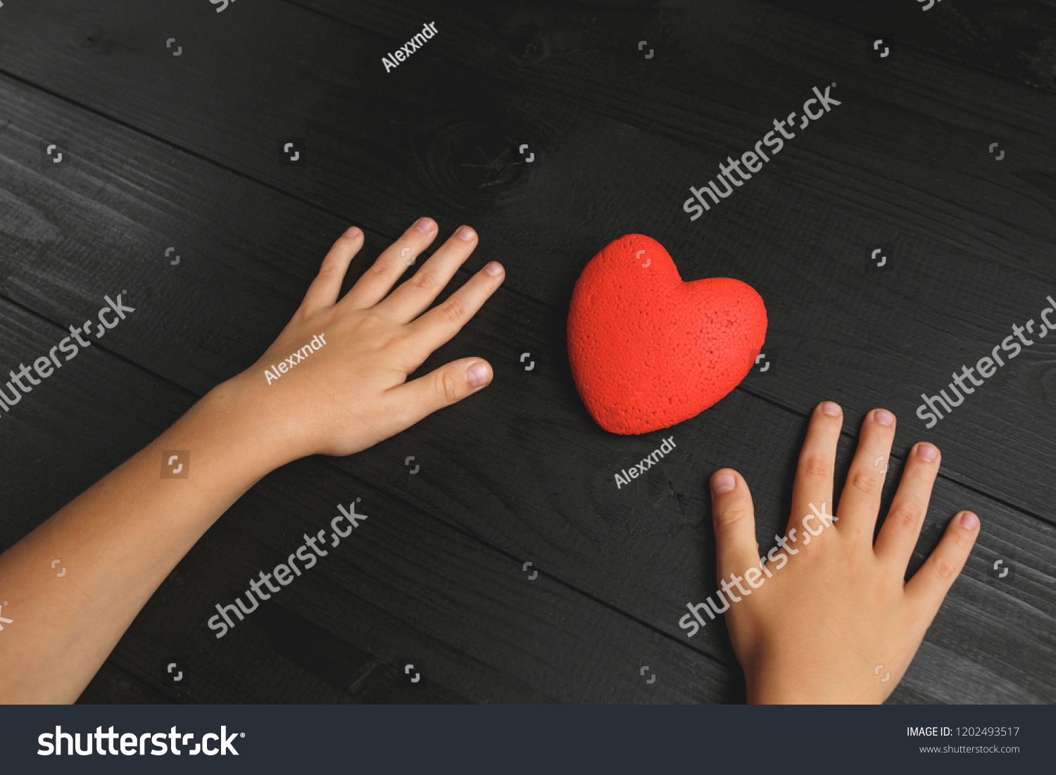 red heart in hands on a dark background, the concept of love and care for loved ones and needy #1202493517