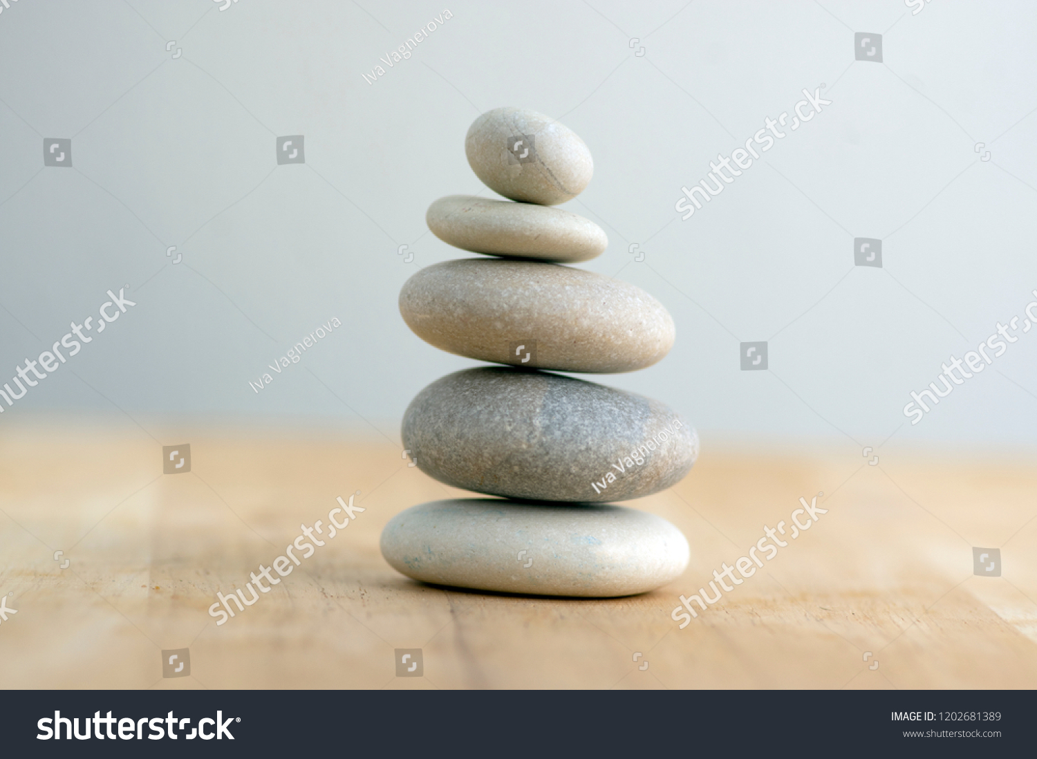 Stone cairn on striped grey white background, five stones tower, simple poise stones, simplicity harmony and balance, rock zen sculptures #1202681389