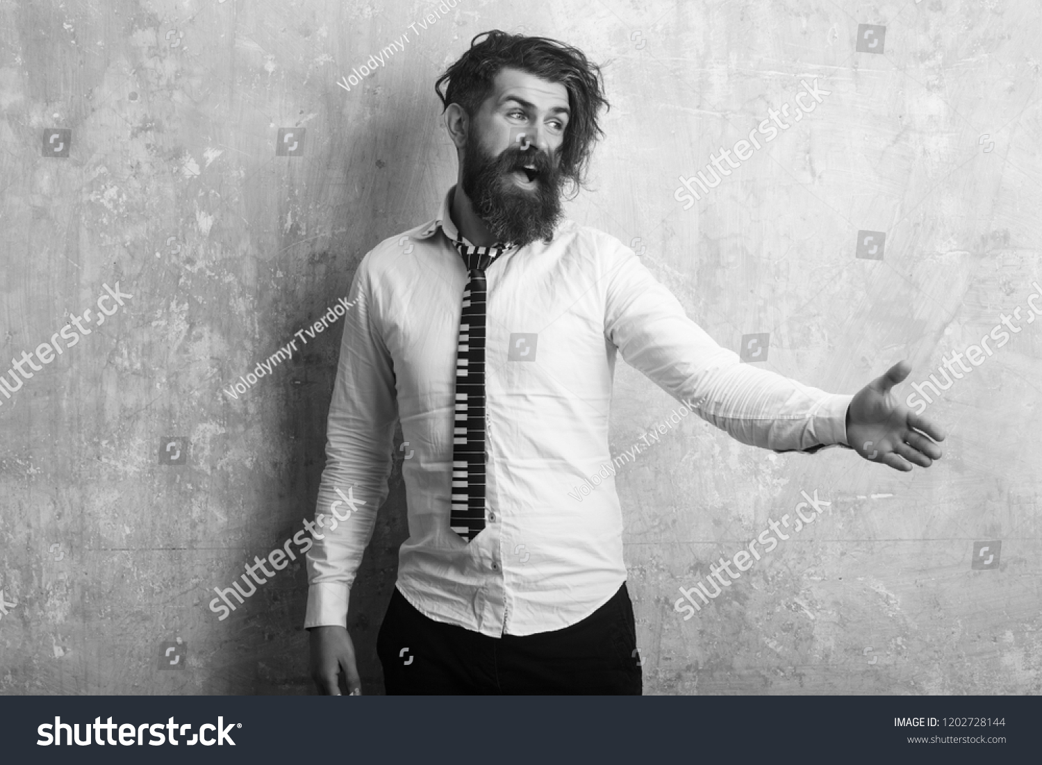 Business fashion and beauty. Guy hold hand for handshake. Man with long beard and mustache on happy face. Fashion model with stylish hair on textured wall background Hipster in shirt and musical tie. #1202728144