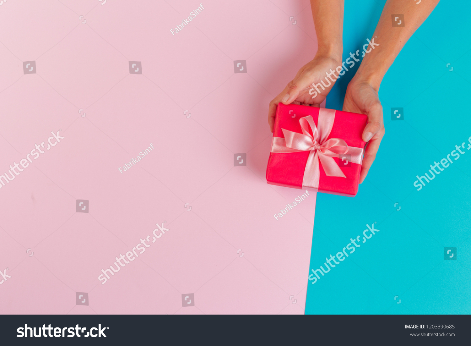 Woman holding gift box on color background #1203390685