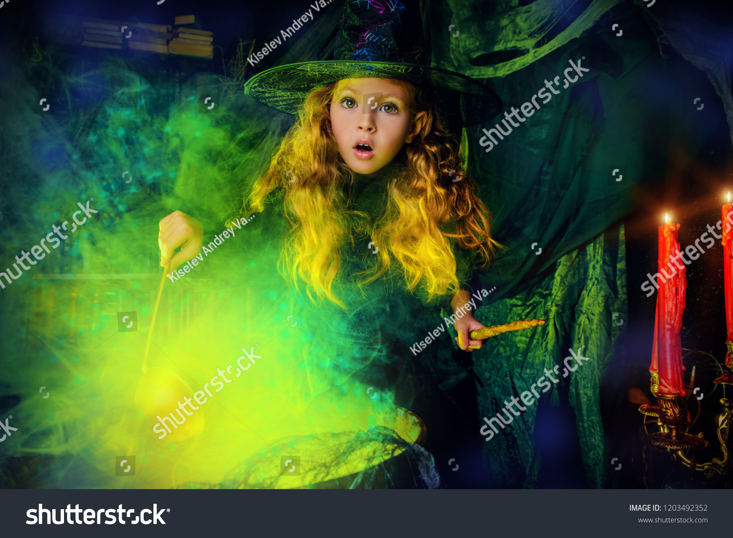 Happy Halloween. Cute child girl in witch costume is in a witch's lair. Cute cheerful little witch cooks a magic potion.  #1203492352