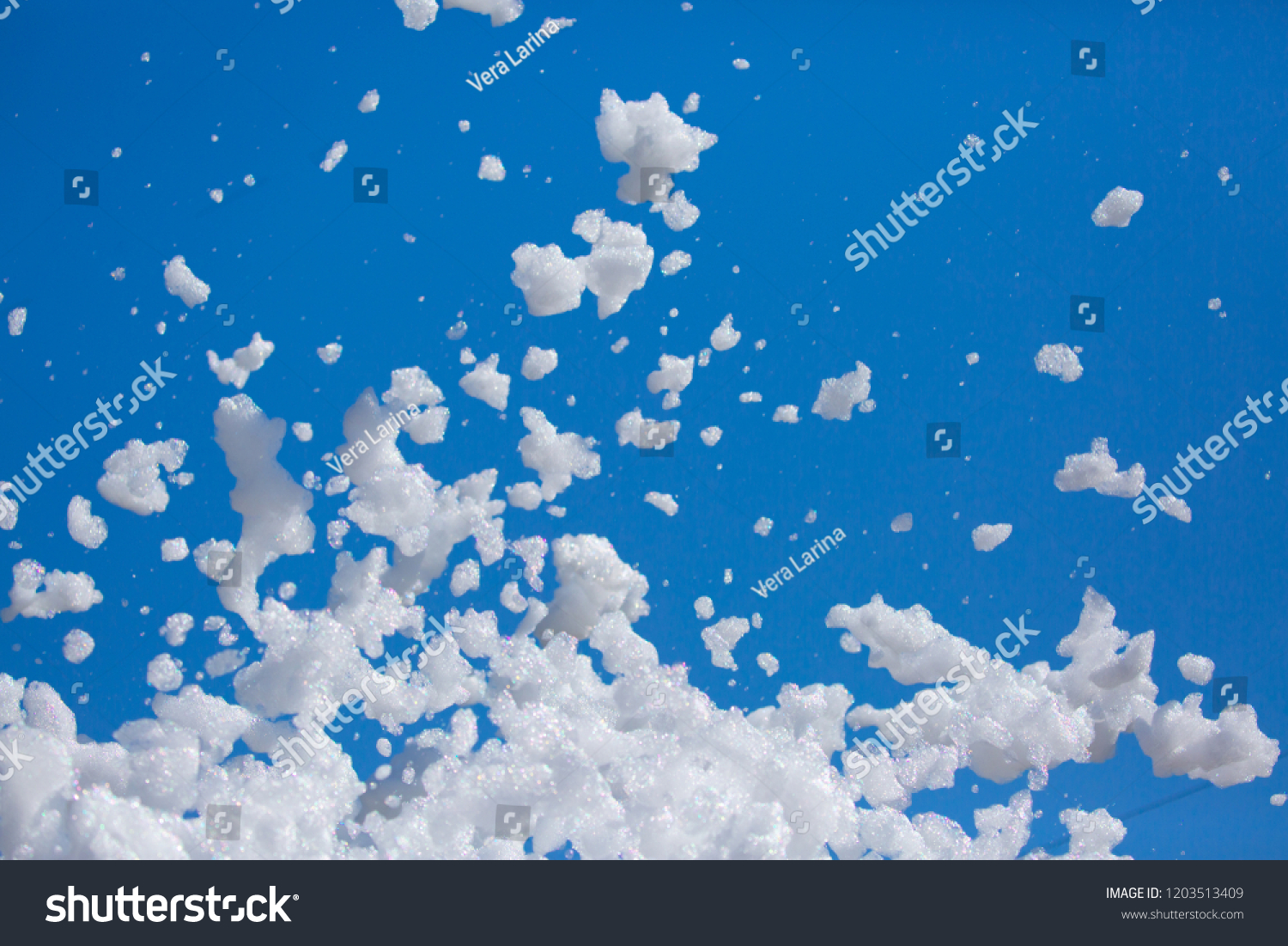 White soap foam on a blue sky background. Fun foam, background or texture of a white foam with copy space Entertainment foamy parties a summer entertainment festival in the water park #1203513409