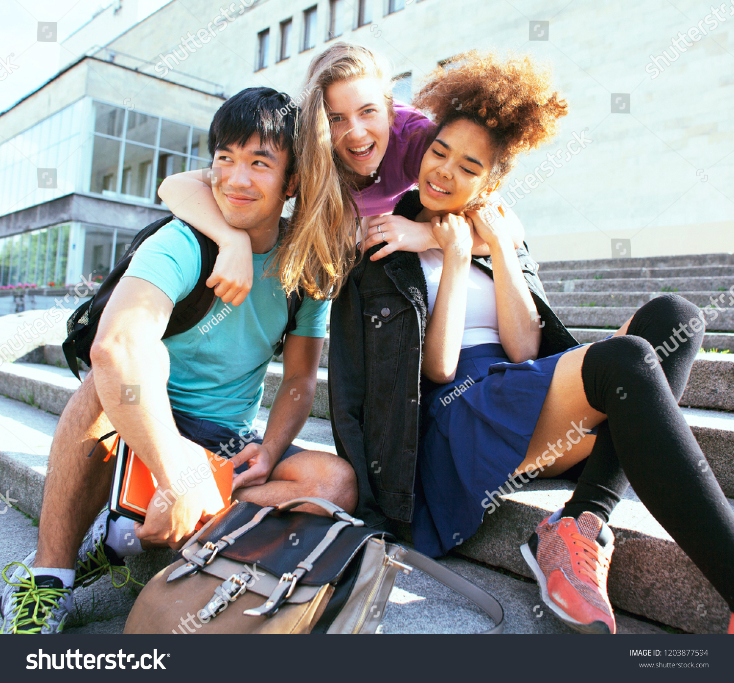 cute group teenages at the building of university with books huggings, back to school #1203877594