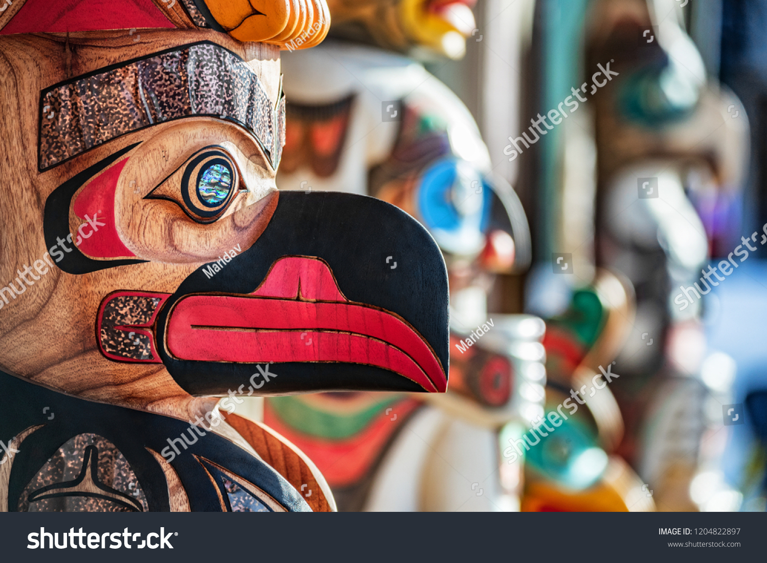 Alaska totem pole carving art sculture store in tourist travel attraction town on Alaska cruise. Ketchikan, Juneau, Skagway stores and shops selling native paintings and art. Closeup of an Eagle. #1204822897