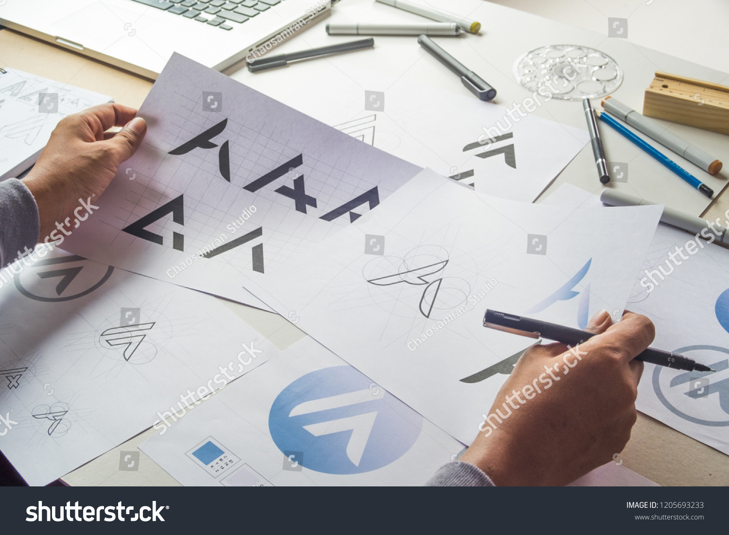 Graphic designer drawing sketch design creative Ideas draft Logo product trademark label brand artwork. Graphic designer studio Concept. #1205693233
