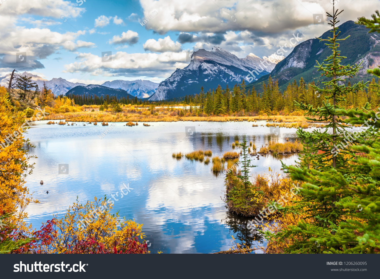 The picturesque lake Vermilion. Warm sunny autumn day. Lush cumulus clouds are reflected in the smooth water of the lake. The concept of ecological, photographic and active tourism #1206260095