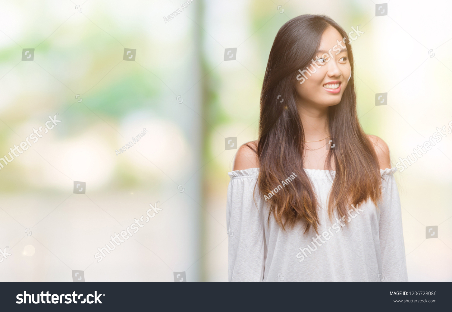 Young asian woman over isolated background smiling looking side and staring away thinking. #1206728086