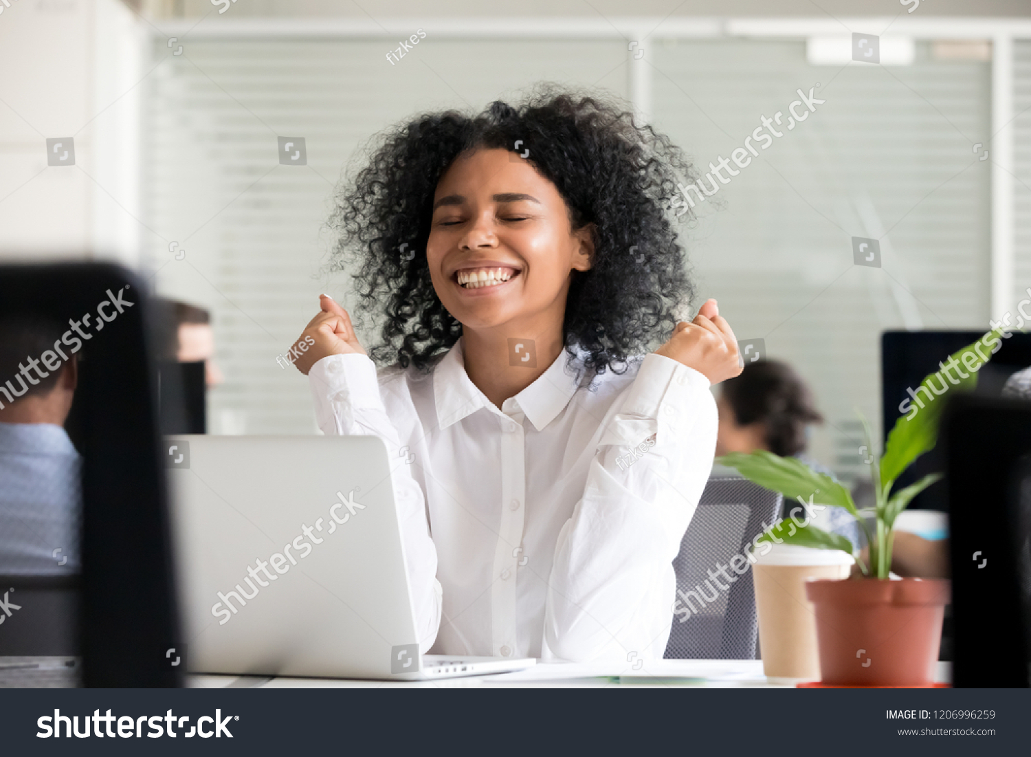 Excited african office worker student receiving good news in email on laptop, motivated happy black female employee getting promoted or rewarded celebrating great result achievement win opportunity #1206996259