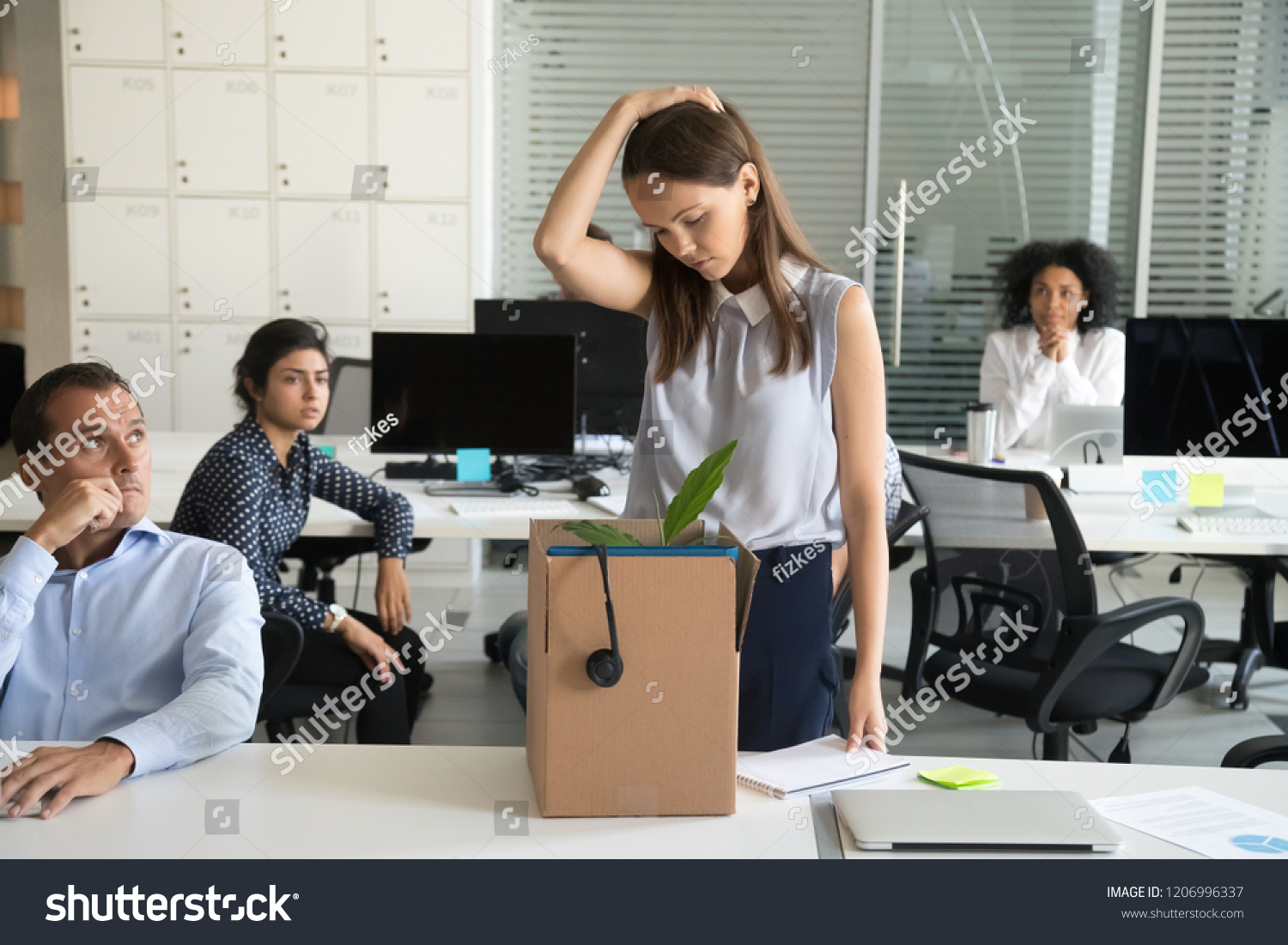 Upset female employee packing belongings in box, frustrated stressed girl getting fired from job ready to leave on last day at work, sad office worker desperate about unfair dismissal losing job #1206996337