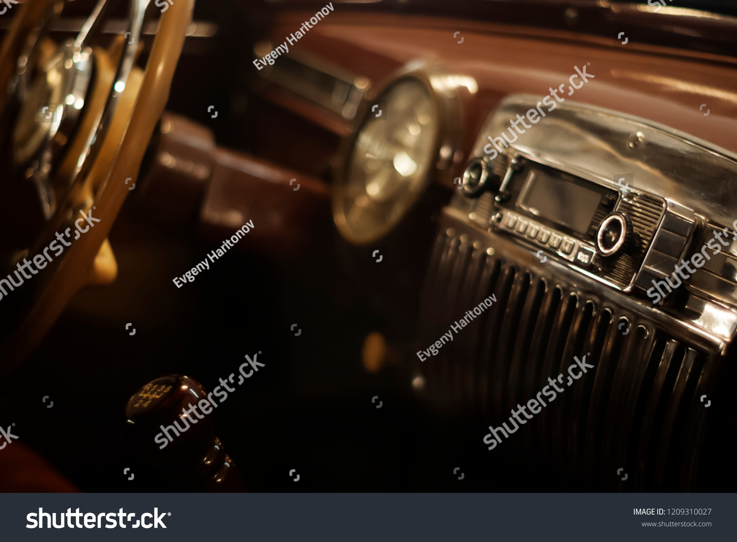 Blurred warm background - a fragment of the interior of a vintage car, focus on the handle of the radio #1209310027