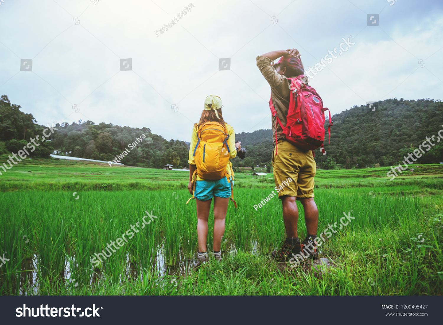 Lover asian man asian women travel nature Travel relax Walking a photo on the rice field in rainy season in Chiang Mai, Thailand #1209495427