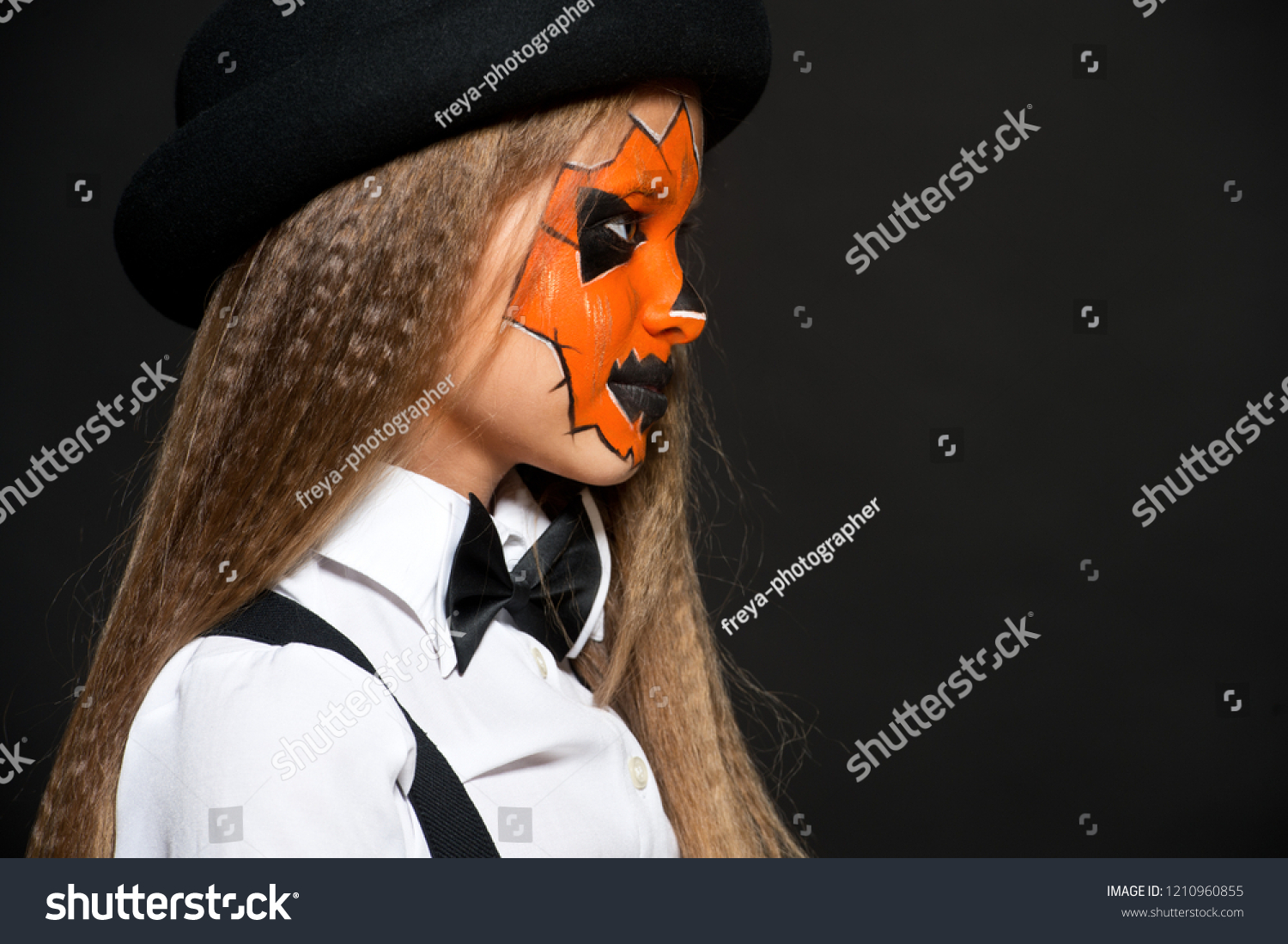 Funny child girl in pumpkin costume for Halloween. Halloween makeup. Face art. #1210960855