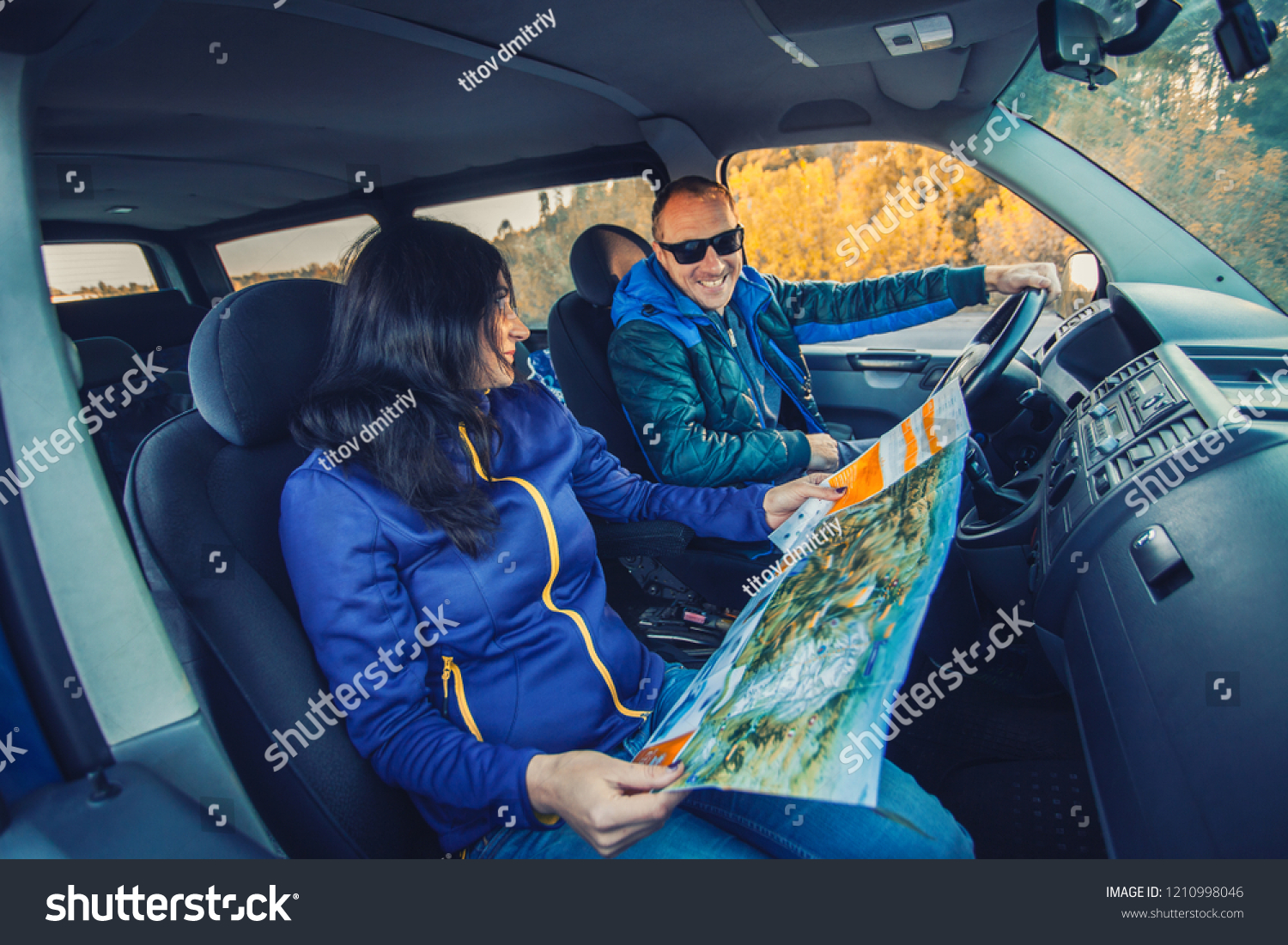 young couple traveling by car through the picturesque autumn forest. transport concept #1210998046