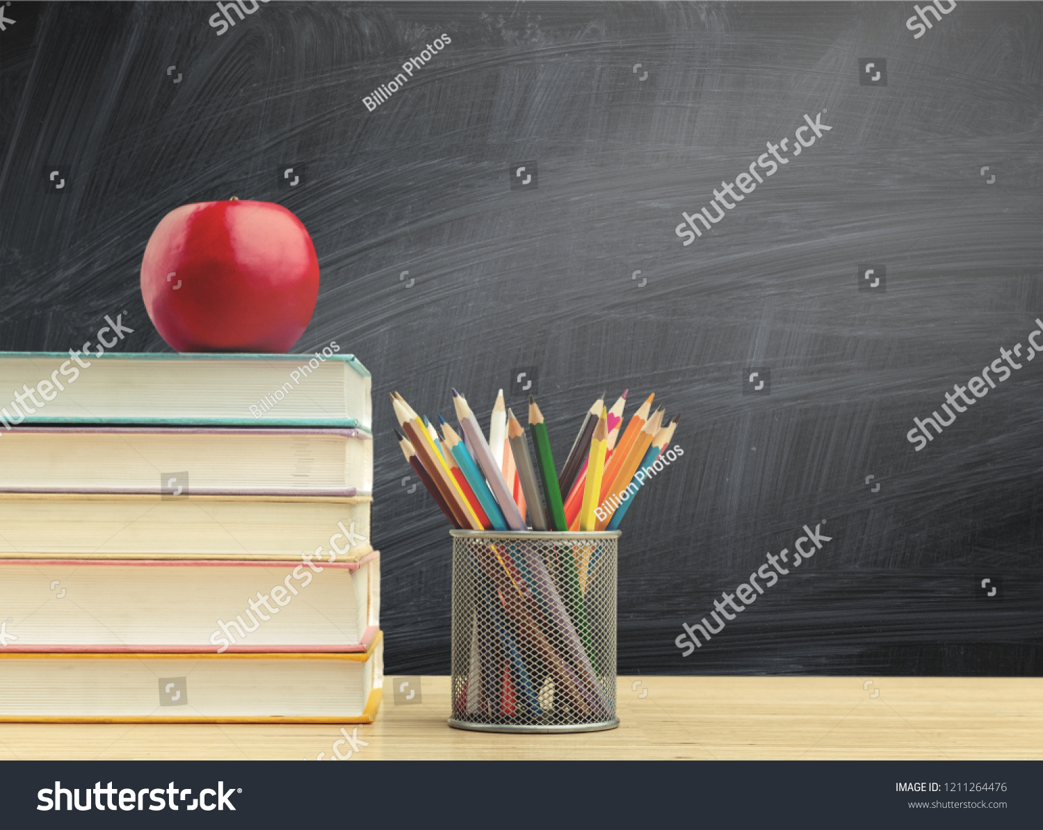 Back to school background with books and apple over blackboard #1211264476