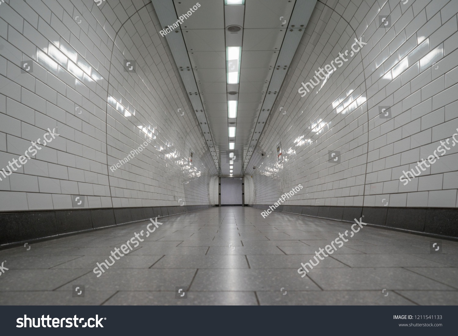 London, UK - October 2018: Empty London Underground white tiled corridor, tunnel #1211541133