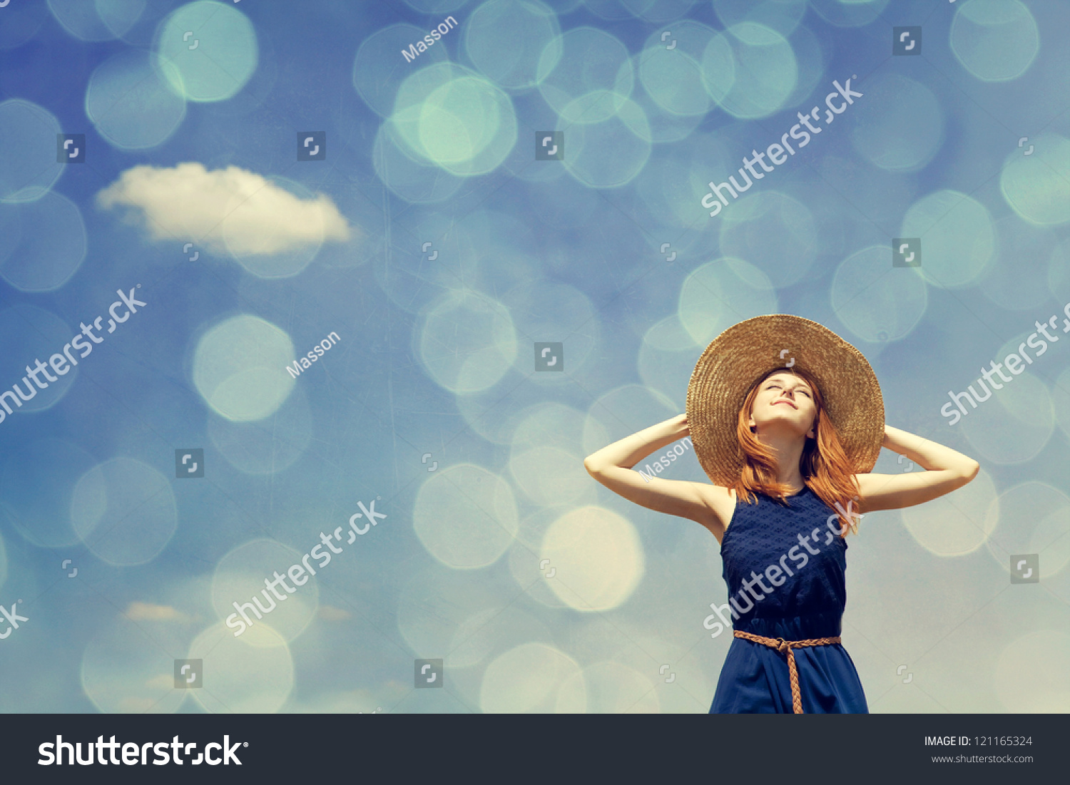 Redhead girl at spring blue sky background. Photo with bokeh at background. #121165324