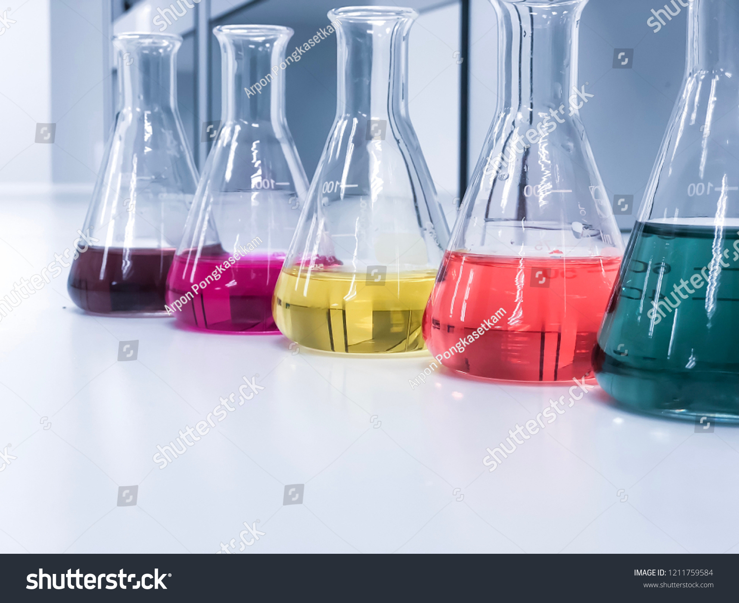 The Erlenmeyer or Conical flask on bench laboratory, with colorful solvent solution from titration experiment, acidity, alkalinity, and total hardness analysis compounding in wastewater sample. #1211759584
