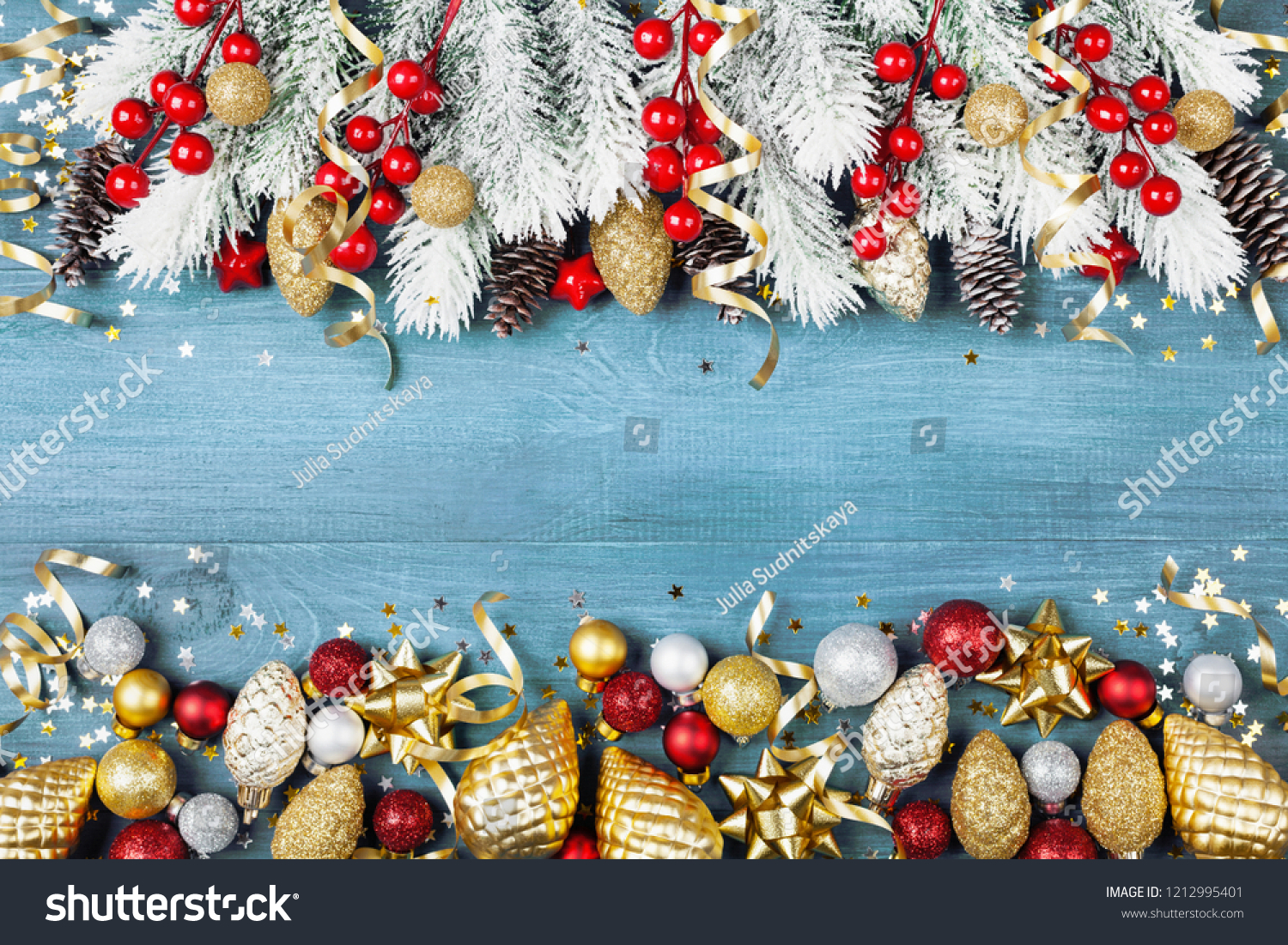 Christmas background with snowy fir tree and shiny holiday decorations on blue wooden table top view. Greeting card with space for text. #1212995401