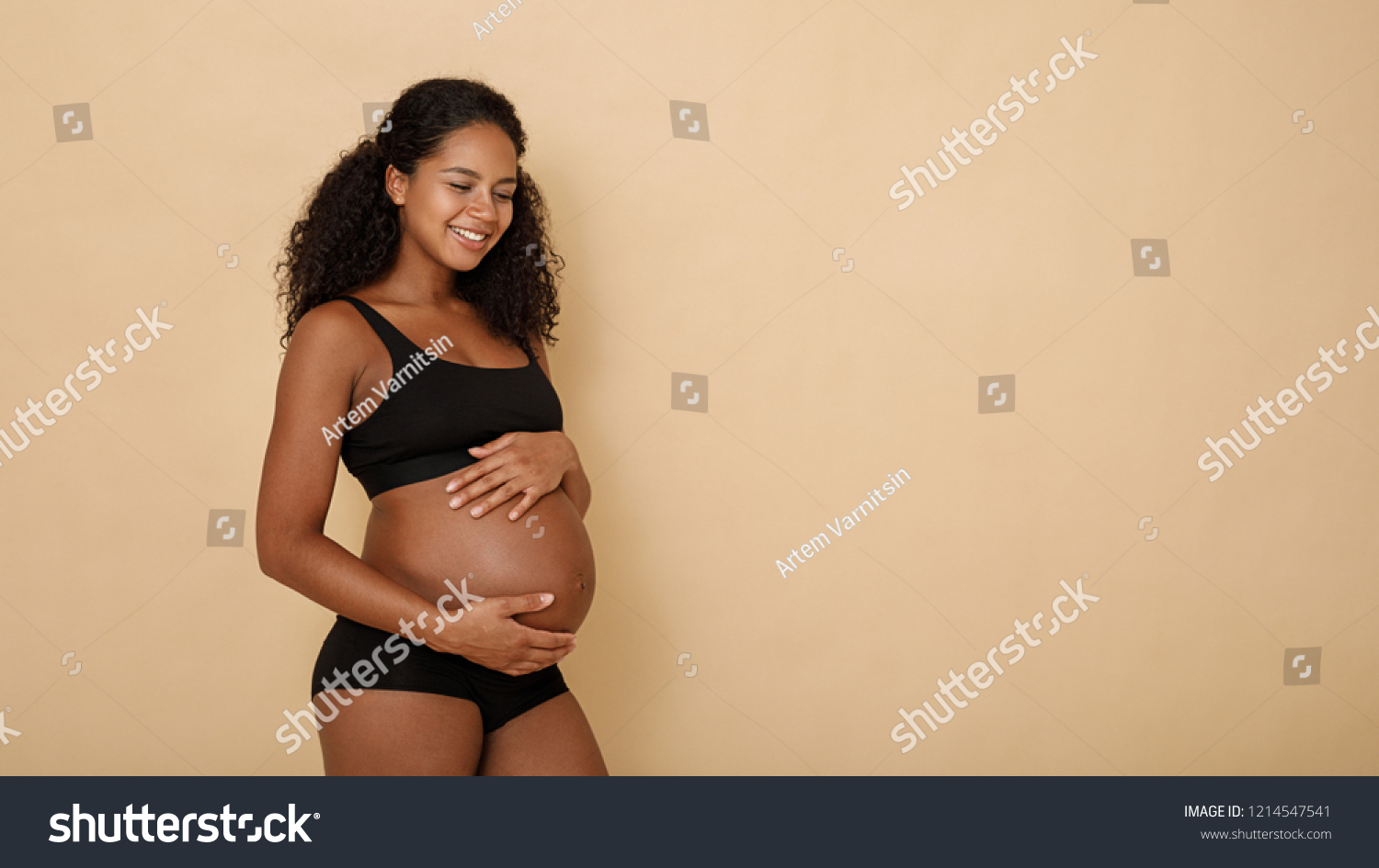 Side view of happy pregnant woman holding her belly #1214547541