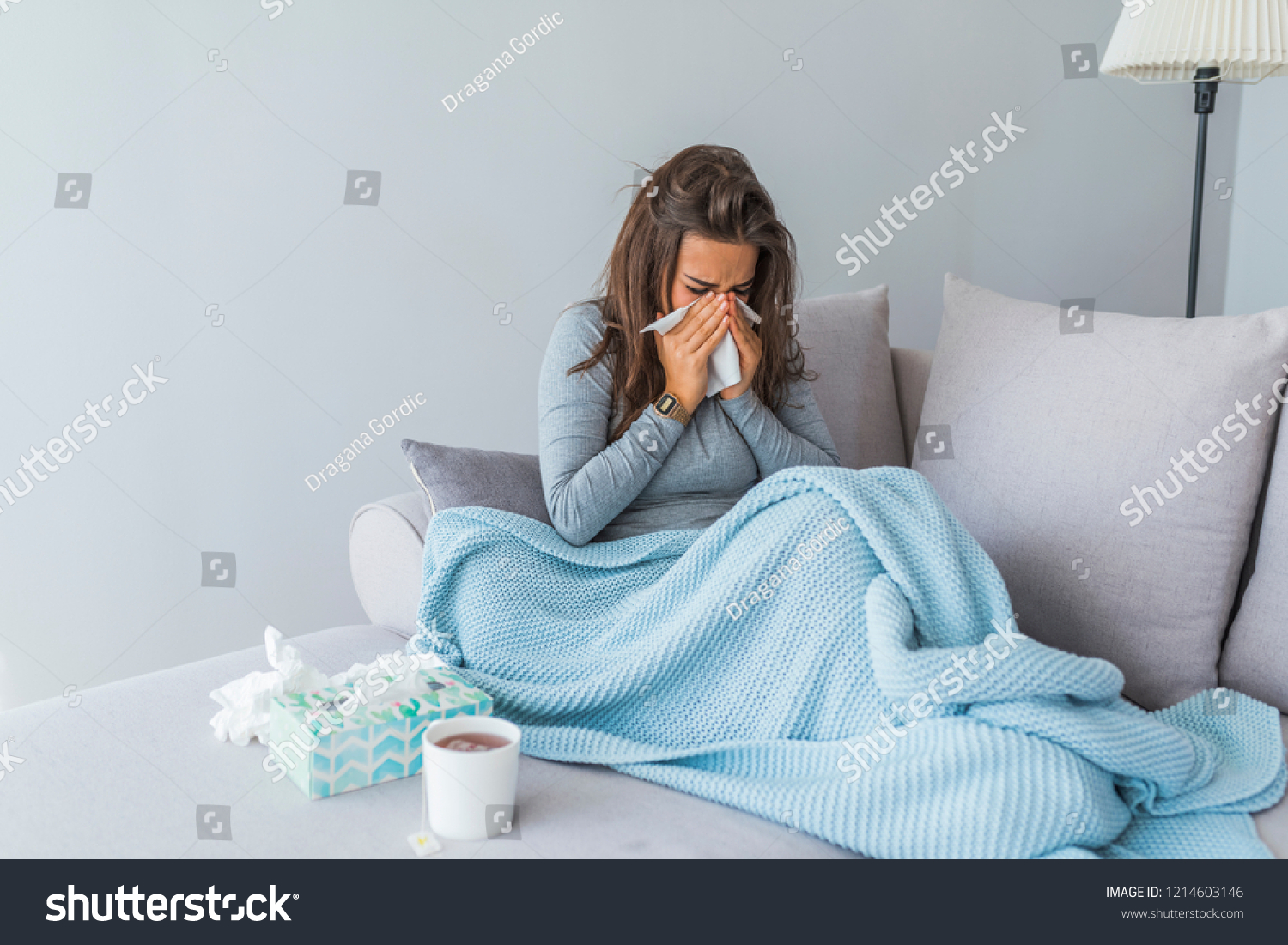 Cold And Flu. Portrait Of Ill Woman Caught Cold, Feeling Sick And Sneezing In Paper Wipe. Closeup Of Beautiful Unhealthy Girl Covered In Blanket Wiping Nose. Healthcare Concept. High Resolution #1214603146