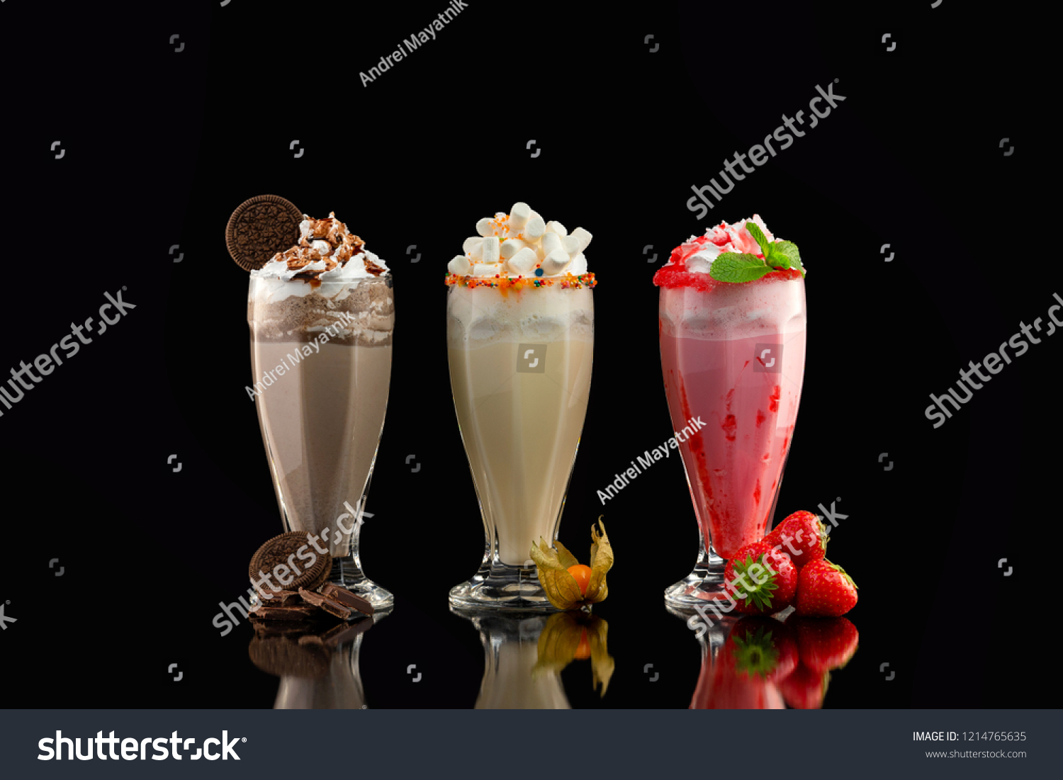 Three glasses of colorful milkshake cocktails - chocolate, strawberry and vanilla decorated with fresh berries and mint isolated at black background. #1214765635