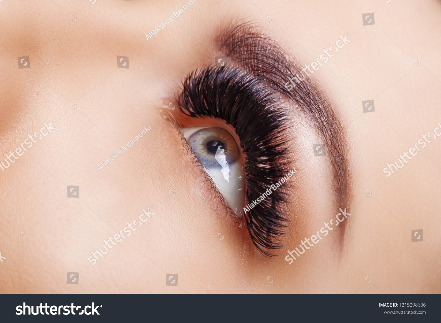 Eyelash Extension Procedure. Woman Eye with Long Eyelashes. Close up, selective focus. Hollywood, russian volume #1215298636