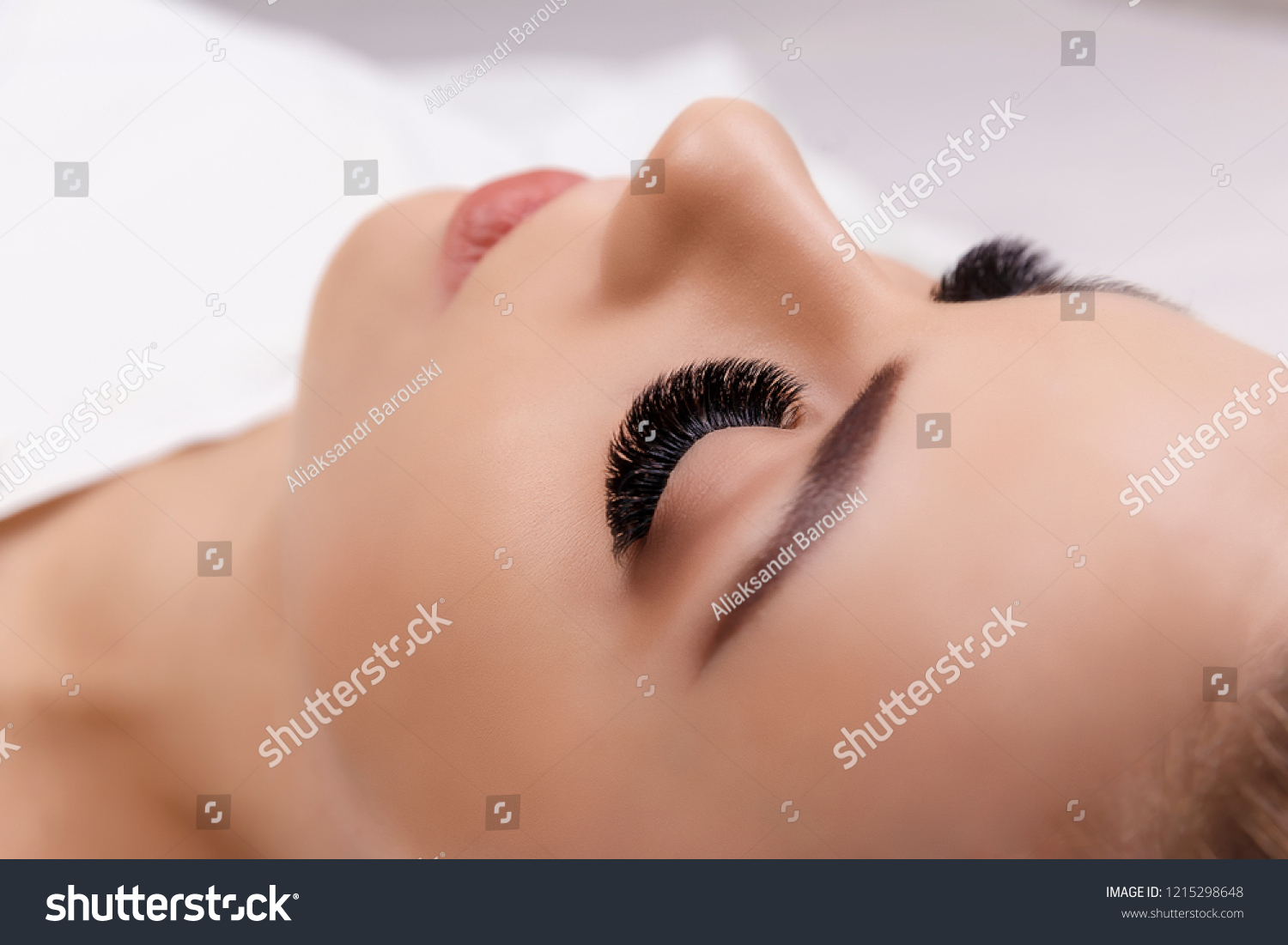 Eyelash Extension Procedure. Woman Eye with Long Eyelashes. Close up, selective focus. Hollywood, russian volume #1215298648