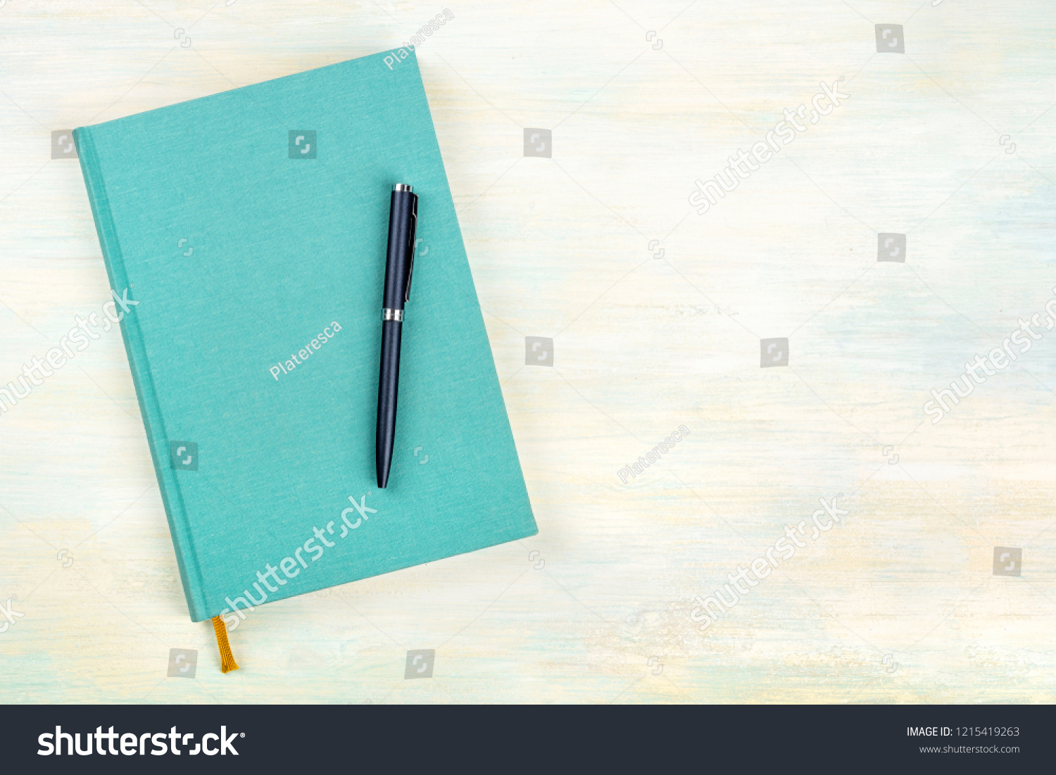 A photo of a teal blue journal with a pen, an elegant diary, notebook or planner, shot from above with copy space #1215419263