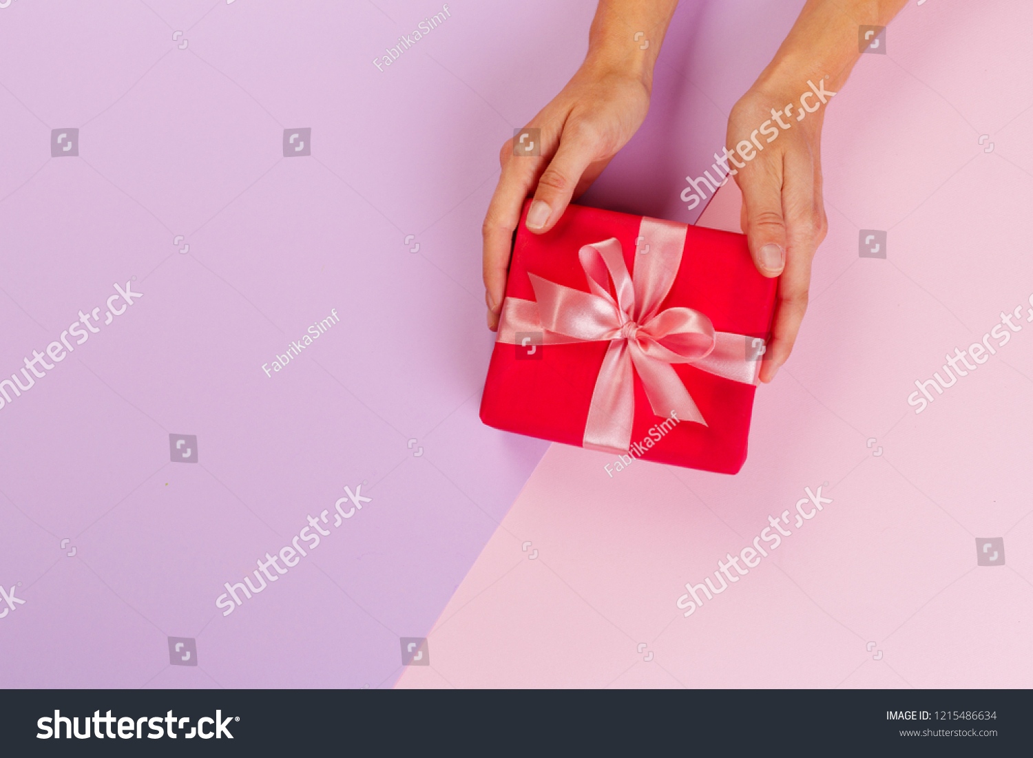 Woman holding gift box on color background #1215486634