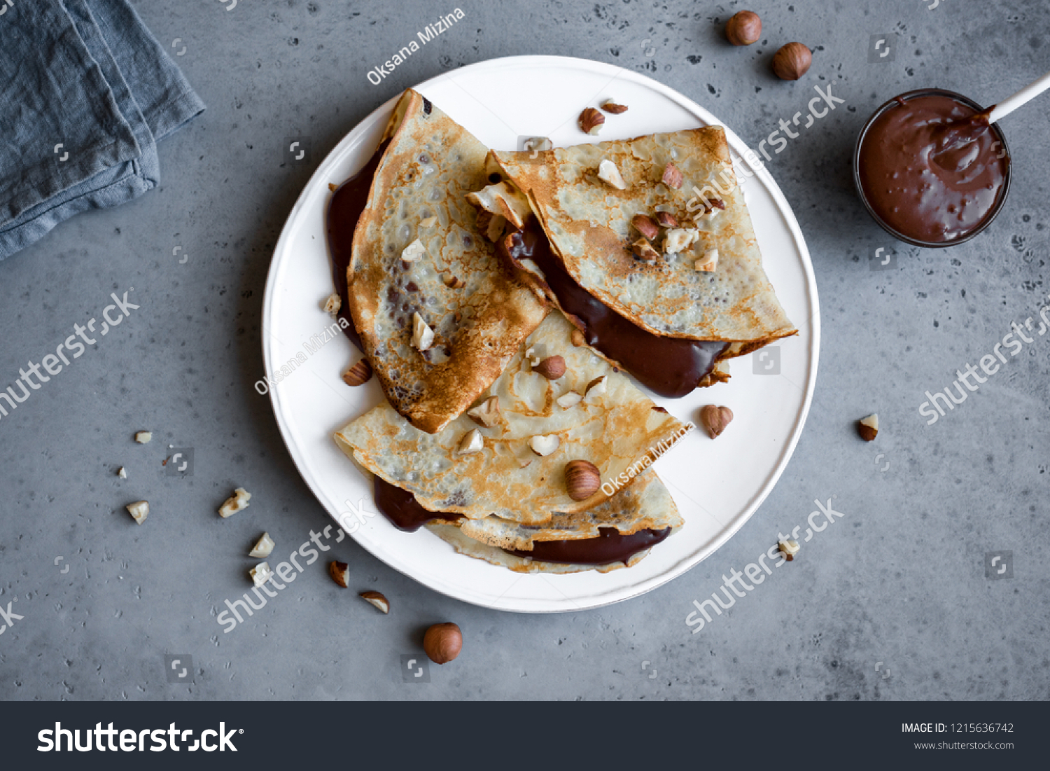 Crepes with chocolate spread and hazelnuts. Homemade thin crepes for breakfast or dessert. #1215636742