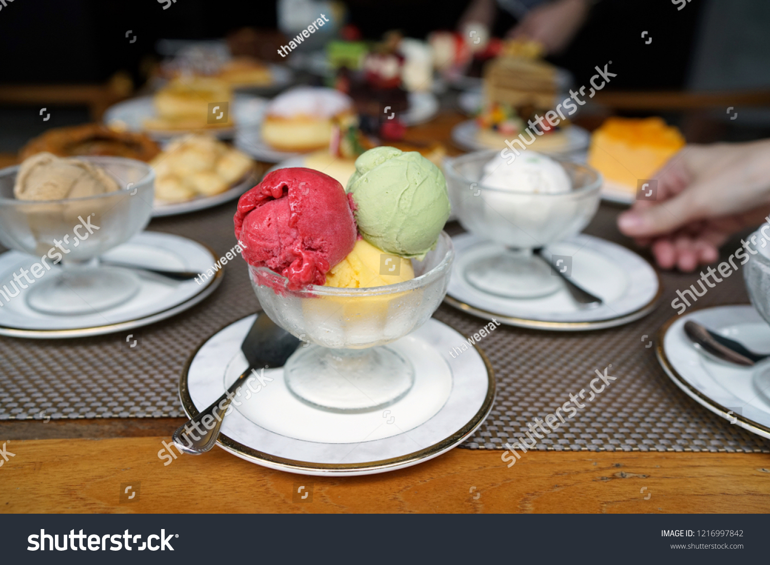 A bowl of ice cream scoops of various flavored, including raspberry, mango and matcha green tea flavours on dessert background. #1216997842