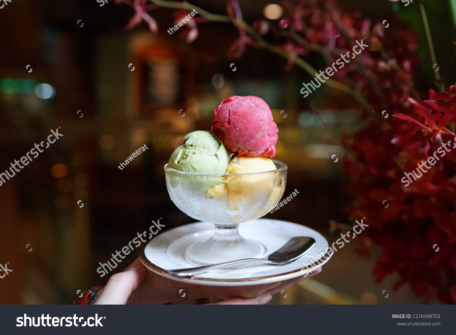 A bowl of ice cream scoops of various flavored, including raspberry, mango and matcha green tea flavours on blurred background. #1216998703