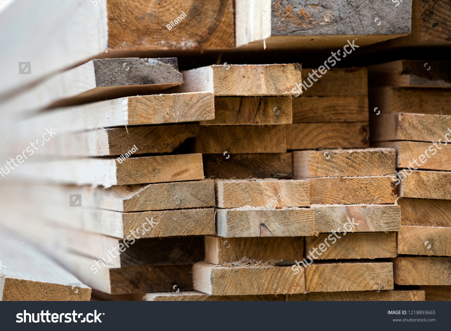 Stack of natural brown uneven rough wooden boards different size, cross-sectional view. Industrial timber for carpentry, building, repairing and furniture, lumber material for construction. #1218893665