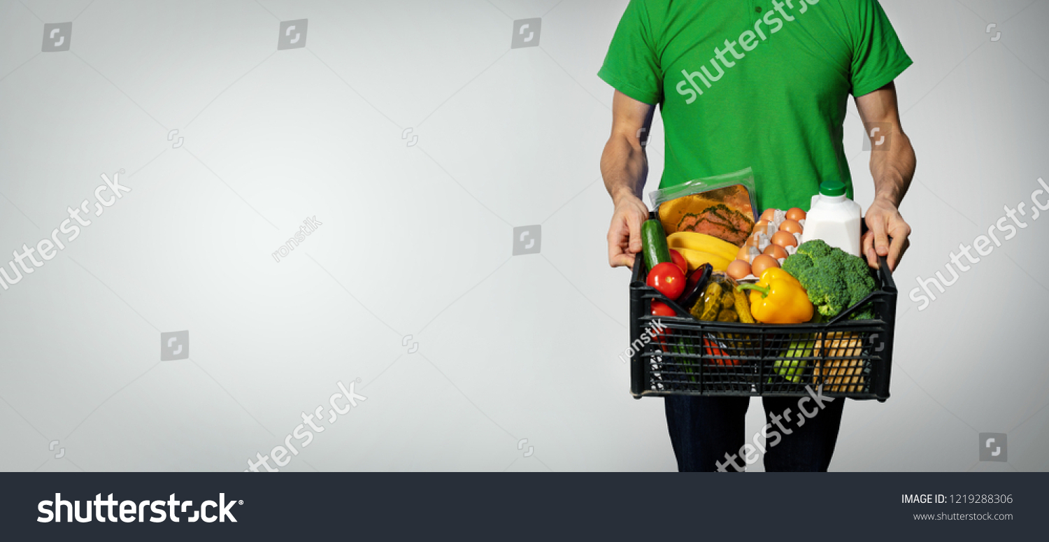 food delivery service - man with groceries box on gray background with copy space #1219288306