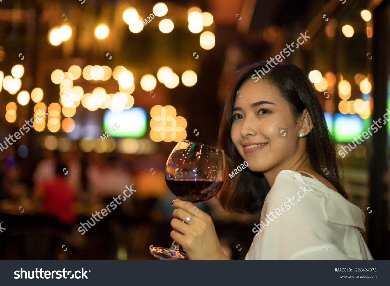 Asian women Enjoying Dinner at Home,Enjoy Concept,Woman drink wine in a nightclub or bar. #1220424073