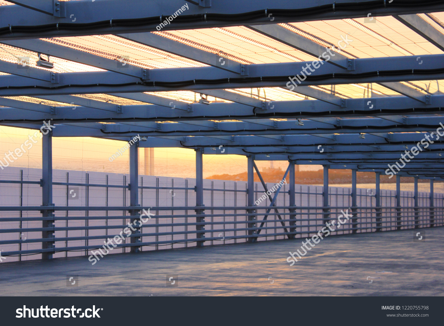 Urban Architecture Abstract Street Passageway Outdoors. Modern Structure of Empty Bridge Road on Evening Sunset Background. Contemporary Urban City Building Interior Passage with Metal Walls and Roof #1220755798
