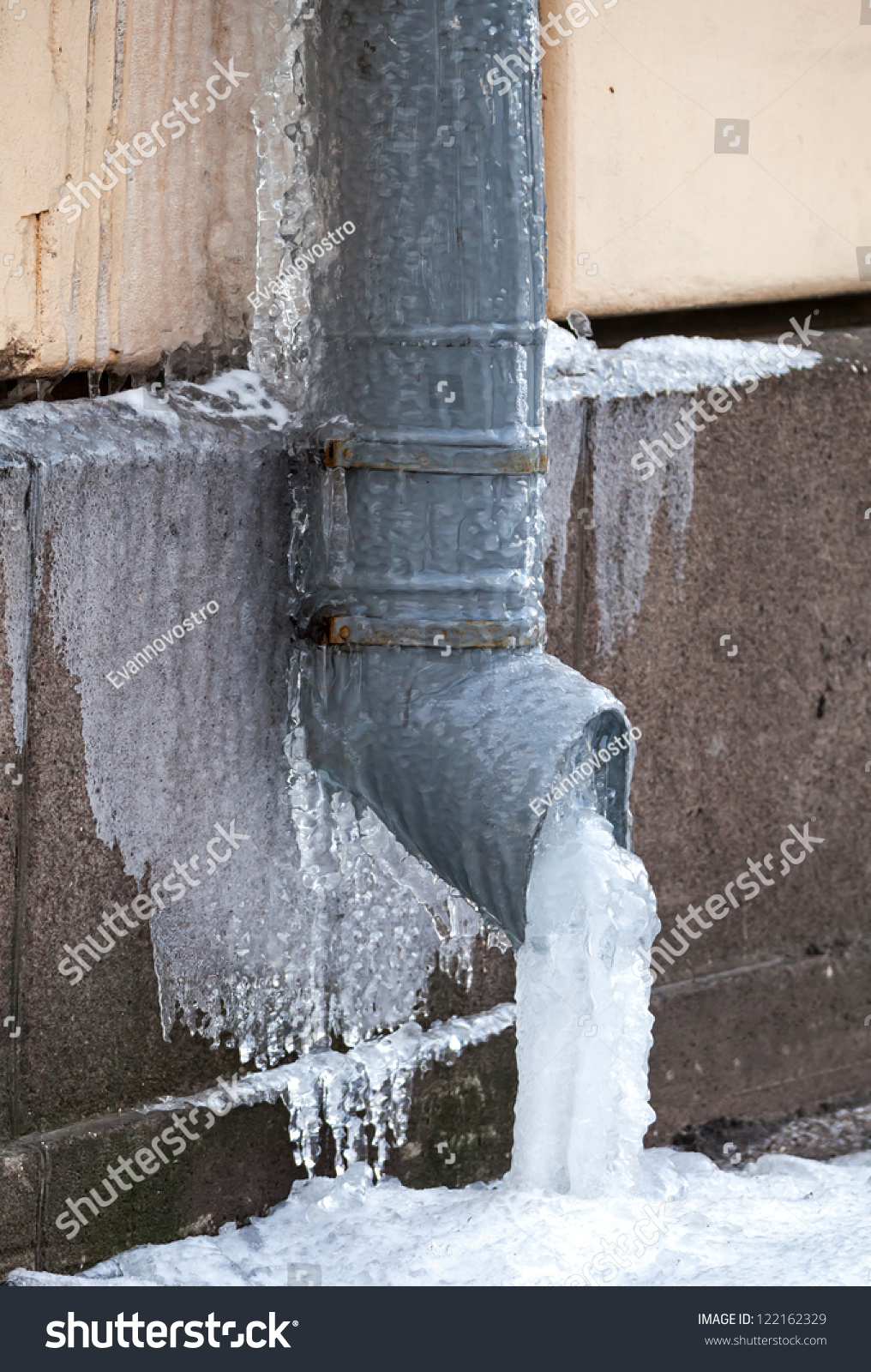 Winter city fragment. Icicles and frost on drainpipe #122162329