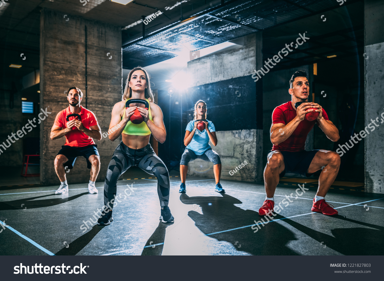 Group of men and women exercising with kettlebell. #1221827803