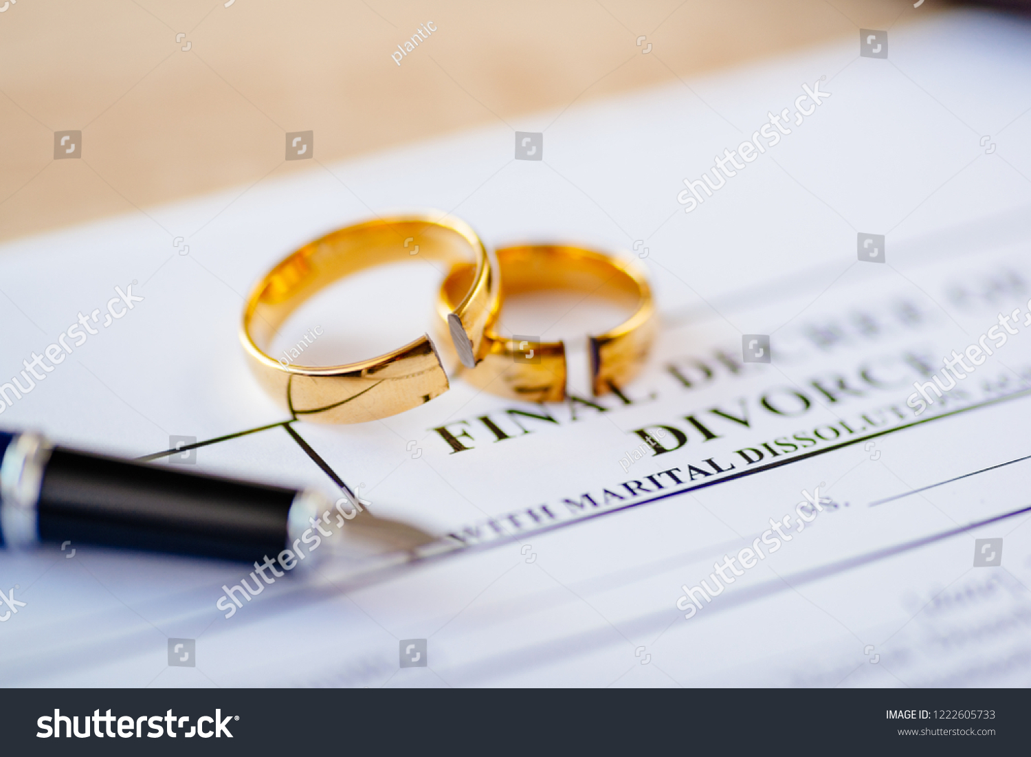 Broken wedding rings on divorce decree. Divorce, separation and family law concept #1222605733