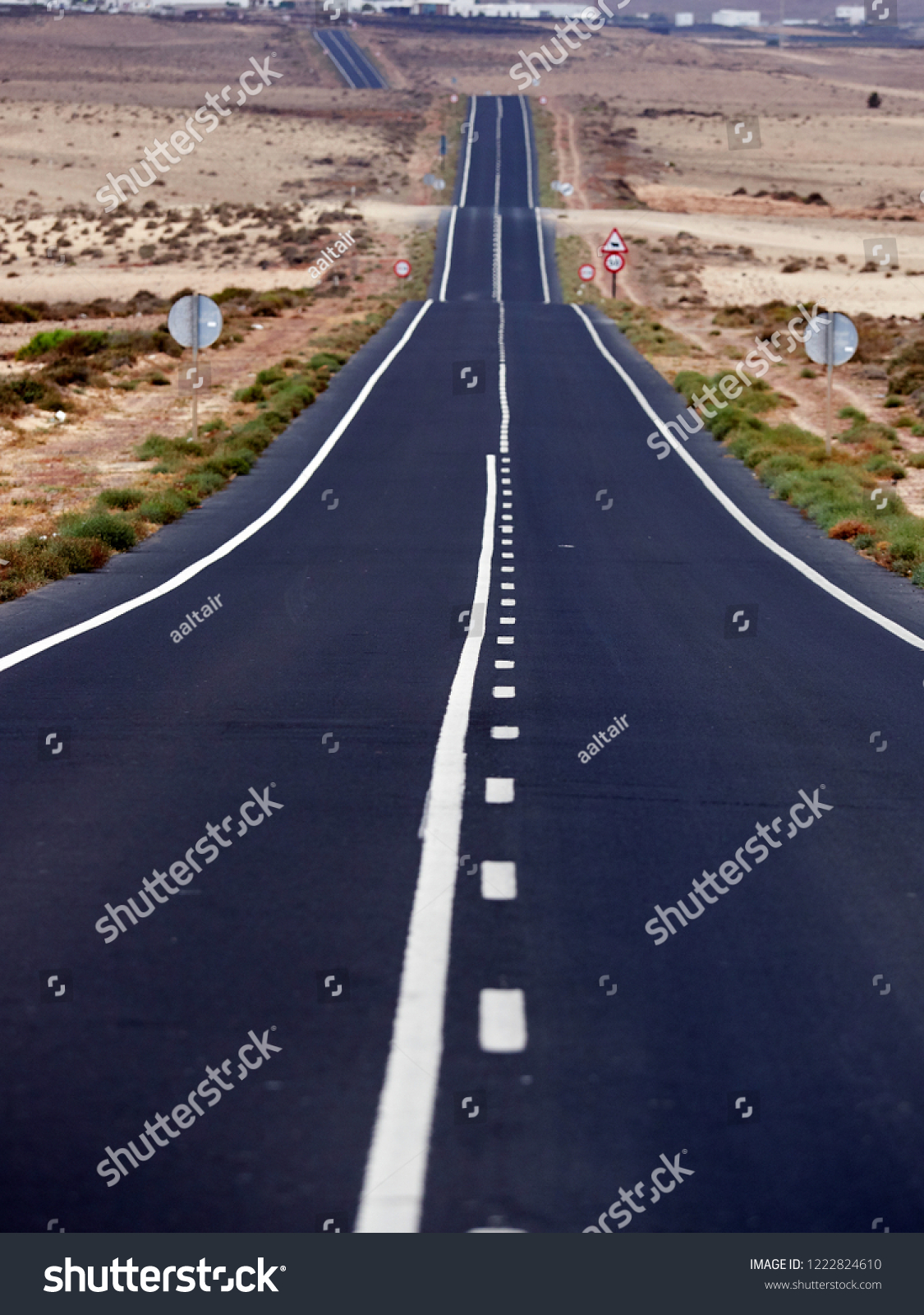 Empty endless highway through the volcanic landscape of Lanzarote island, Canary islands, Spain #1222824610