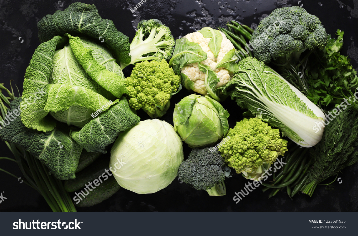 Different kinds of cabbage background in black table. Green vegetables. Broccoli, Savoy cabbage, White cabbage, cauliflower, Peking cabbage. Cucumbers, asparagus, herbs. Healthy diet food. #1223681935
