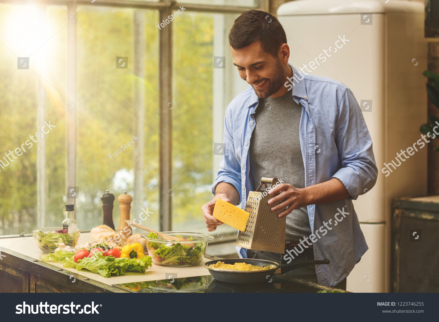 Man preparing delicious and healthy food in the home kitchen on a sunny day.  #1223746255